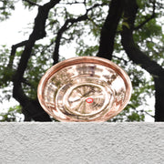 Copper plate on a stone ledge with trees in the background